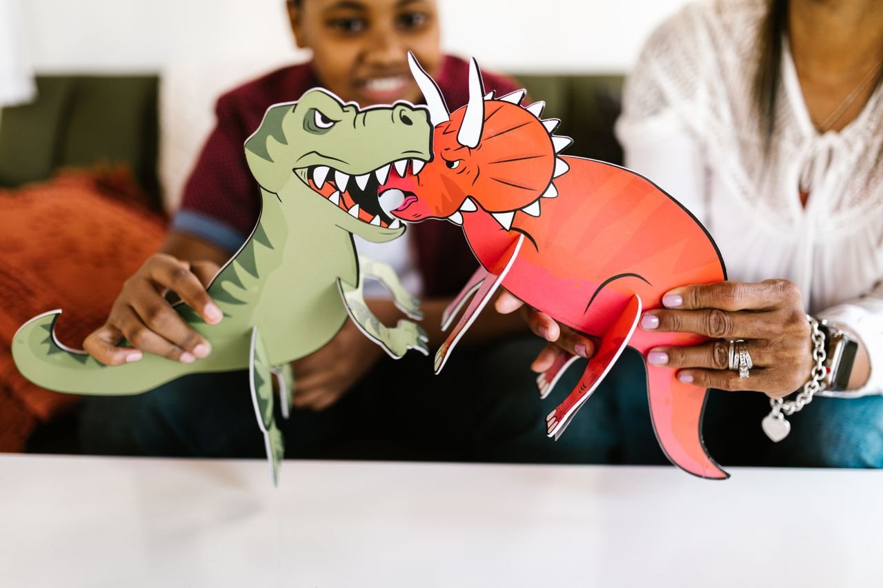 collection-02 Children creatively crafting with colorful dinosaur paper cutouts for a fun and educational activity.