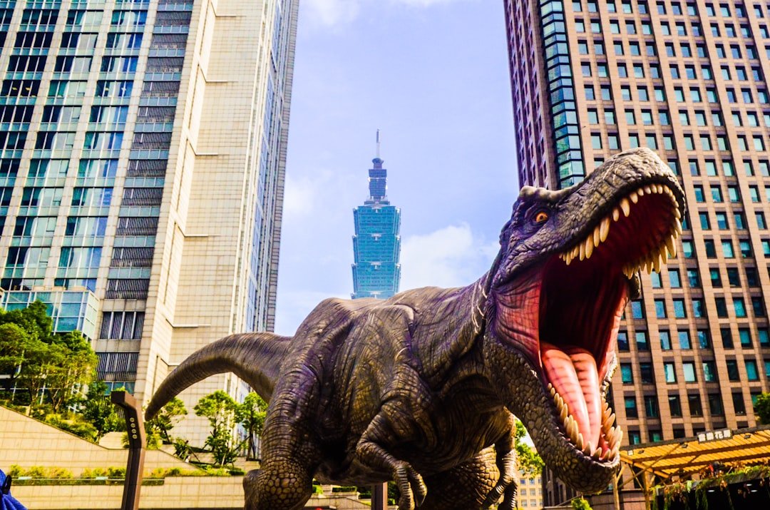 about-us-02 dinosaur-with-open-mouth-beside-buildings-still-selective-focus-photography-of-7-yzujmd8ae